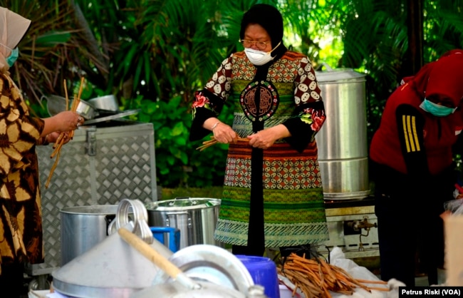 Wali Kota Surabaya Tri Rismaharini terlibat dalam aktivitas penyediaan minuman dan makanan tambahan di dapur umum. (Foto: VOA/Petrus Riski)