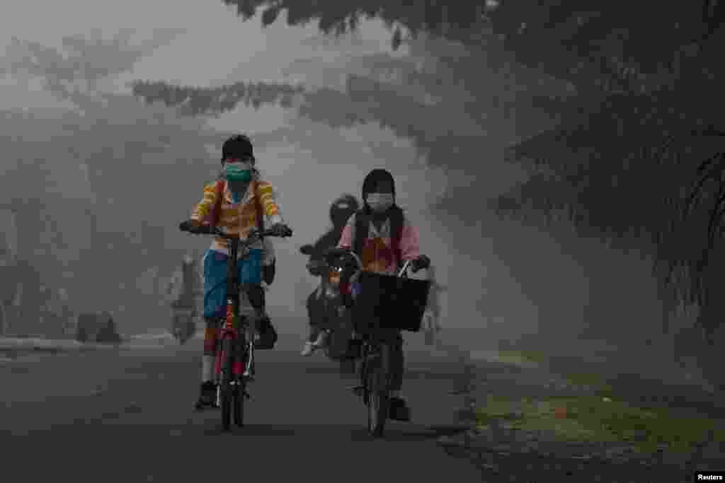 طالب علم سائیکل پر سوار ہو کر اسکول جا رہے ہیں۔