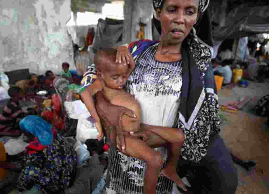 Una mujer desplazada internamente llega al asentamiento en la capital de Somalia, Mogadishu, Julio 19, 2011.