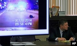 FILE - A police vehicle dash cam video of the moments after Laquan McDonald was fatally shot is displayed for jurors as Chicago police Officer Jason Van Dyke attends his first-degree murder trial for the shooting death of McDonald, at the Leighton Criminal Court Building in Chicago, Oct. 3, 2018.