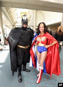 FILE - Husband and wife team Ken and Michelle Camarillo, in Batman and Wonder Woman costumes, pose for a photo on the second day of the 2015 Comic-Con International held at the San Diego Convention Center, July 10, 2015, in San Diego.