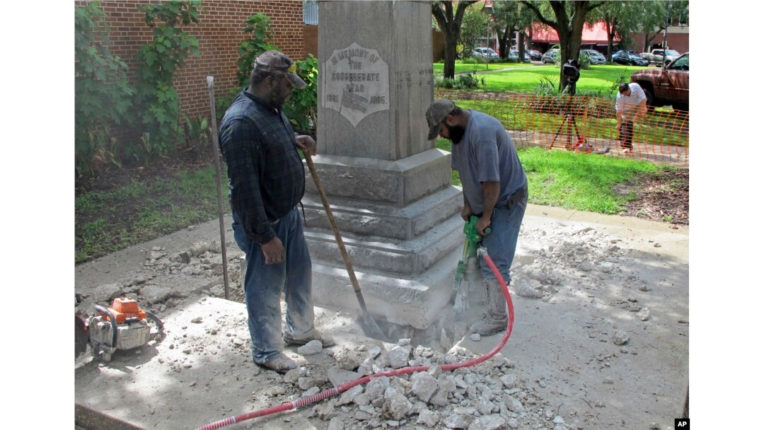 FILE - Workers begin removing a Confederate statue in Gainesivlle, Fla., Aug. 14, 2017. The statue is being returned to the local chapter of the United Daughters of the Confederacy, which erected the bronze statue in 1904.