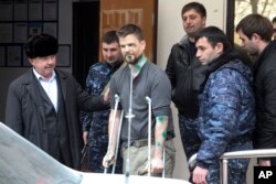 FILE - Norwegian reporter Oystein Windstad, one of a group of journalists and activists attacked by assailants near Chechnya, leaves a hospital in Ordzhonikidzevskaya, Ingushetia province, March 11, 2016. The journalists were investigating human rights abuses in Russia's North Caucasus when they were waylaid by cars full of masked men.