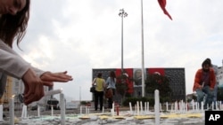 People light candles in victims' memory of recent protests at Taksim Square in Istanbul, June 14, 2013. 