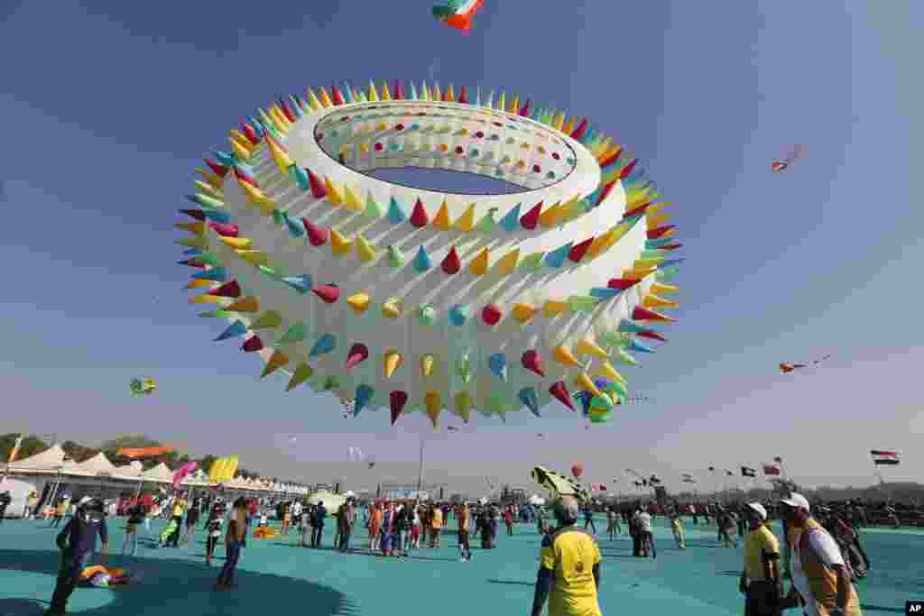 Indians watch a huge kite fly during International kite festival in Ahmadabad,