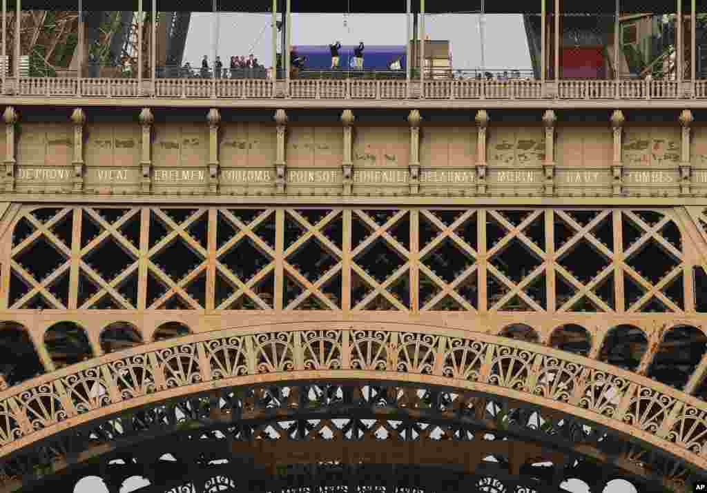 Europe's Ryder Cup captain Thomas Bjorn, top left, and U.S. Ryder Cup captain, Jim Furyk hit a drive off the first story of the Eiffel Tower in Paris, France, Oct. 17, 2017.