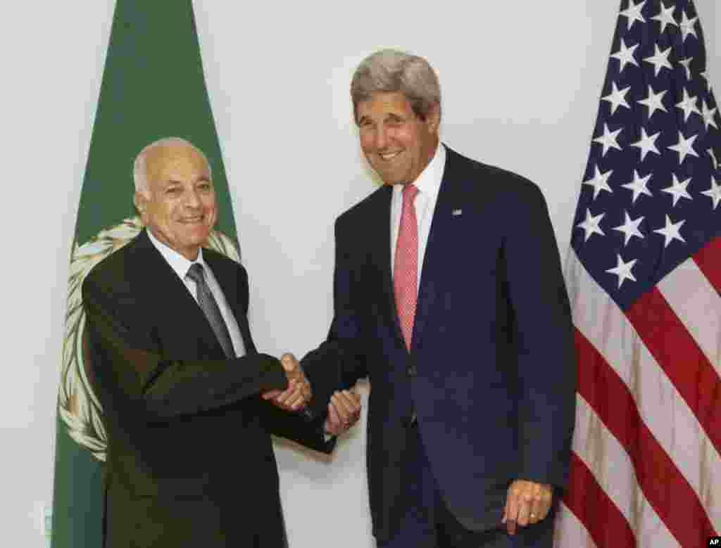Menteri Luar Negeri AS John Kerry (kanan) berjabat tangan dengan Sekretaris Jenderal Liga Arab Nabil Elaraby sebelum rapat mereka di Kairo (13/9). (AP/Amr Nabil)