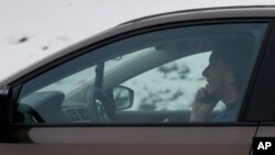 FILE -A motorist talks on a cell phone while driving on an expressway in Chicago, Dec. 19, 2013. 