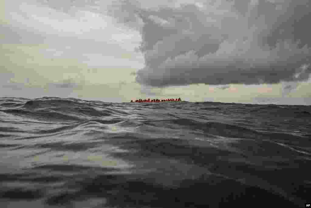 Refugees and migrants wait to be rescued by aid workers of the Spanish NGO Proactiva Open Arms, after leaving Libya and trying to reach European soil aboard an overcrowded rubber boat,&nbsp; north of Al-Khums, Libya.