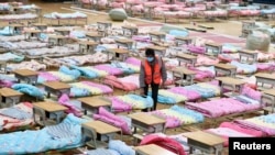 武汉洪山体育馆被改成临时医院，工作人员搭起多个床位以收容新冠病毒感染者。（2020年2月4日）