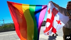 FILE - Georgian LGBT activists attend a rally against homophobia outside the State Chancellery to mark international day against homophobia, in downtown Tbilisi, Georgia, Wednesday, May 17, 2017.