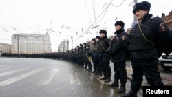 Riot police stand guard during a march to commemorate Kremlin critic Boris Nemtsov, who was shot dead on Friday night, in central Moscow March 1, 2015. Opposition supporters march through Moscow on March 1 in memory of Nemtsov, whose murder has increased 