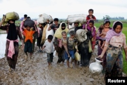 A group of Rohingya refugees walk on a muddy road after traveling over the Bangladesh-Myanmar border in Teknaf, Bangladesh, Sept. 1, 2017.