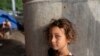 En la foto de archivo una niña hondureña quien espera el desayuno cocinado por su familia debajo de un puente en las afueras de San Pedro Sula, Honduras, el lunes 11 de enero de 2021.