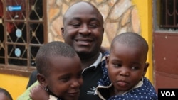 Bosco Segawa with two of the former street kids at his orphanage in Kampala, Uganda, Oct. 25, 2013. (VOA/Hilary Heuler))