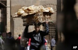 FILE - An Egyptian bread vendor looks for clients on el-Moez Street in historic Fatimid Cairo, March 12, 2015. In the privatization and investment drive of the 2000s, Egypt¹s economy achieved impressive economic growth, but it failed to translate into wider prosperity.
