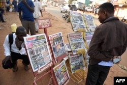 People gather around a newspaper stand to read the local daily papers on Feb. 17, 2016 ahead of tomorrow’s presidential elections.