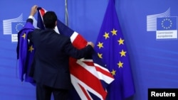 FILE - Flags are arranged at the EU Commission headquarters ahead of a first full round of talks on Brexit, Britain's divorce terms from the European Union, in Brussels, Belgium, July 17, 2017. 