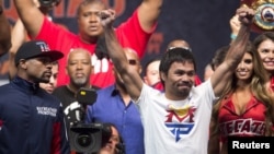 Manny Pacquiao (kanan) dalam penimbangan berat badan resmi di MGM Grand Garden Arena di Las Vegas, Nevada (1/5). (Reuters/Steve Marcus)