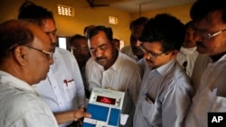 Indian election officials seal an electronic voting machine after the closing of a polling center in Kunwarpur village, Uttar Pradesh state, India, May 12, 2014. 