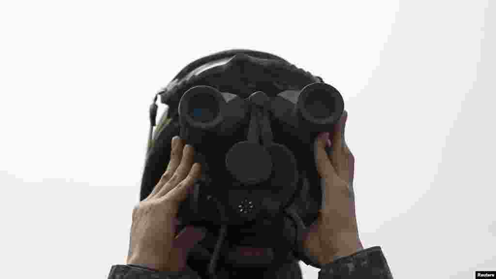 A South Korean army soldier looks at the mock target through a pair of binocular during a U.S.-South Korea joint live-fire military exercise at a training field in Pocheon, South Korea. &nbsp;