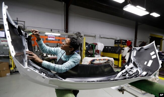 FILE - Final inspector Mary Skinner inspects the rear end of a General Motors Chevrolet Cruze at Jamestown Industries, Nov. 28, 2018, in Youngstown, Ohio.