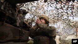 FILE - A Ukrainian soldier at a fighting position on the line of separation from pro-Russian rebels near Debaltsevo, Donetsk region, Ukraine, Ukraine, Dec 3, 2021. 