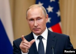 Russian President Vladimir Putin gestures during a joint news conference with U.S. President Donald Trump after their meeting in Helsinki, Finland, July 16, 2018.
