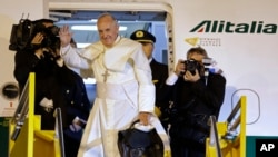 Pope Francis waves good-bye after climbing the stairs to the plane taking him back to Rome, in Asuncion, Paraguay, July 12, 2015.