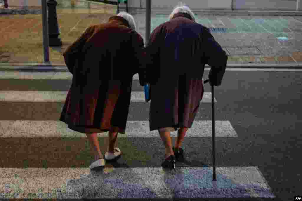 Twin sisters walk in a street in the French riviera city of Nice.