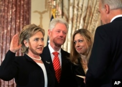 Vice President Joe Biden, right, swears in Secretary of State Hillary Clinton in a ceremonial swearing-in at the State Department in Washington, accompanied by her husband, former President Bill Clinton, and their daughter, Chelsea.