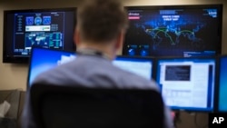 2015年5月20日，位於俄亥俄州哥倫布的AEP總部的網絡安全運營中心，一名安全專家看著電腦，牆上屏幕顯示網絡威脅地圖。