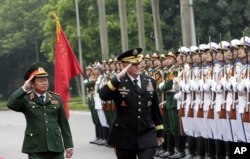 Chủ tịch Hội đồng Tham mưu trưởng Liên quân Hoa Kỳ Martin Dempsey, phải, và vị đồng cấp Việt Nam, Đại Tướng Đỗ Bá Tỵ, trái, duyệt hàng quân danh dự trước khi đàm phán ở Hà Nội, ngày 14/8/2014.