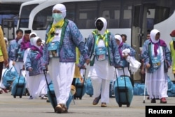 FILE - Indonesian Haj pilgrims walk towards their flight at the airport in Solo, Central Java province, Indonesia, Sept. 17, 2015, in this photo taken by Antara Foto.