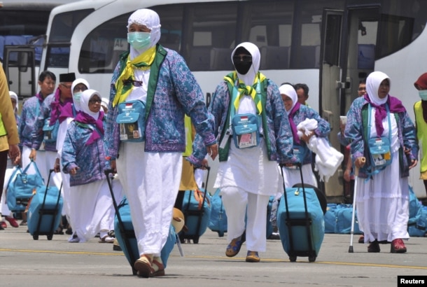 FILE - Indonesian Haj pilgrims walk towards their flight at the airport in Solo, Central Java province, Indonesia, Sept. 17, 2015, in this photo taken by Antara Foto.