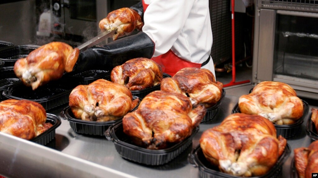 FILE - In this May 8, 2008, file photo, a butcher spreads out rotisserie-roasted chicken at Costco in Mountain View, California. (AP Photo/Paul Sakuma, File)