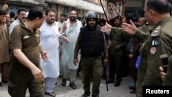 Supporters of the Pakistan-Muslim League - Nawaz (PML-N) are handcuffed and escorted by police after they were appeared before district court in Rawalpindi, July 11, 2018.