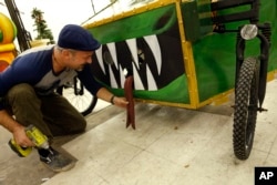 Ryan Ballard, founder of the Krewe of Chewbacchus Mardi Gras parade, makes adjustments to a hand made silicone tongue on a float at their headquarters at the Castillo Blanco Art Studios in New Orleans, Jan. 2, 2016.