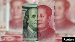 Foto ilustrasi: mata uang pecahan 100-dolar AS vs. 100-yuan China. 