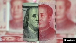 FILE - U.S. 100-dollar banknote featuring American founder Benjamin Franklin and a Chinese 100-yuan banknote featuring late Chinese chairman Mao Zedong are seen in this picture illustration.