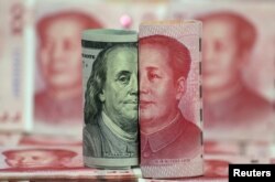 FILE - U.S. 100-dollar banknote featuring American founder Benjamin Franklin and a Chinese 100-yuan banknote featuring late Chinese chairman Mao Zedong are seen in this picture illustration.