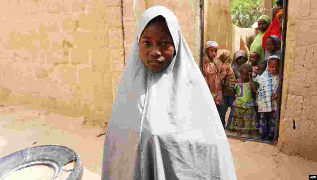 Hassana Mohammed, 13, who scaled a fence to escape an alleged Boko Haram attack on her Government Girls Science and Technical College, stands outside her home in Dapchi, Nigeria.