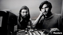 Apple Chief Executive Officer Steve Jobs stands beneath a photograph of him and Apple-co founder Steve Wozniak from the early days of Apple during the launch of Apple's new "iPad" tablet computing device in San Francisco, California, January 27, 2010. 