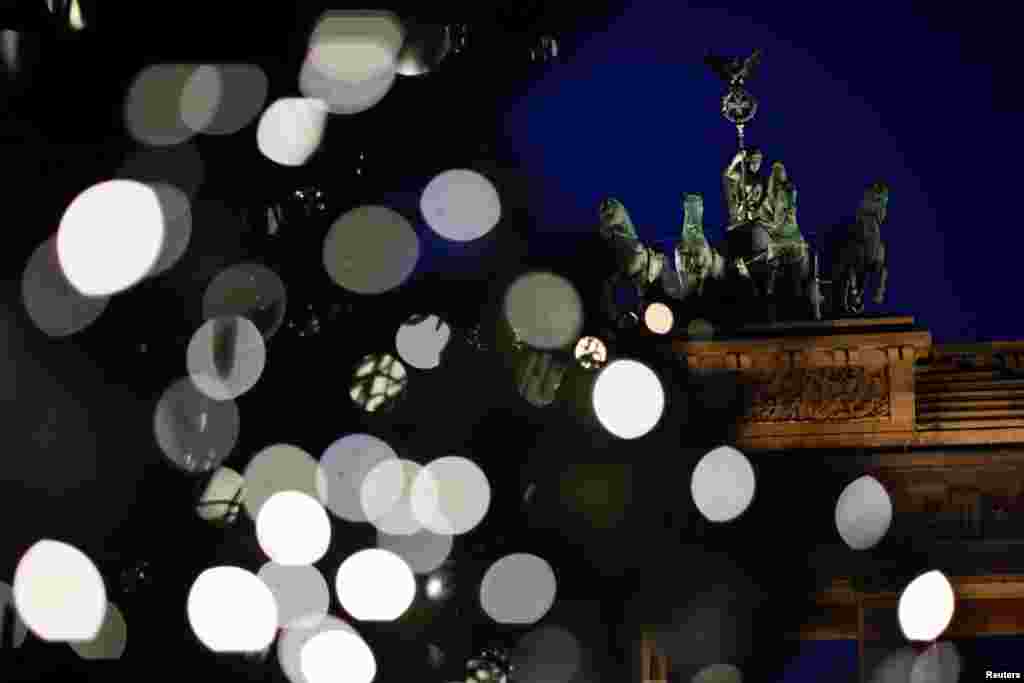 A Christmas tree is illuminated in front of Brandenburg Gate in Berlin, Germany, November 26, 2020. REUTERS/Hannibal Hanschke TPX IMAGES OF THE DAY
