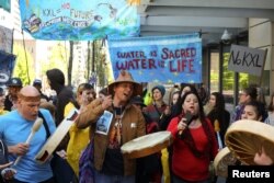 Native American leaders and climate activists join together in song outside of a Chase Bank location in Seattle, Washington, to oppose the Keystone XL pipeline, May 8, 2017.