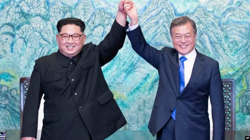 朝鲜领导人金正恩(左)和韩国总统文在寅在板门店签署一项联合声明后举起握在一起的手 (2018年4月27日)