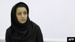FILE - A picture taken on July 8, 2007 shows Iranian Reyhaneh Jabbari standing handcuffed at police headquarters in Tehran after she was arrested for the murder of a former intelligence official. 