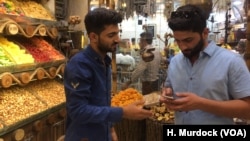 Saman Sadq, left, in his family's sweets and nuts shop, says that for him, Kurdish independence is a natural right, in Erbil, Kurdish Iraq, Sept. 5, 2017. 