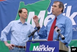 FILE - Jeff Merkley, then a Democratic candidate for the U.S. Senate, right, speaks at a rally with Oregon Sen. Ron Wyden, in Portland, May 31, 2008.