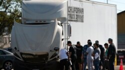 Student drivers gather around a practice truck to inspect the vehicle at California Truck Driving Academy in Inglewood, Calif., Nov. 15, 2021.